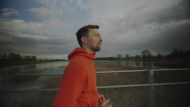 Corsa Fondo Campagna Uomo Felpa Arancione Che Attraversa Ponte Legno — Video Stock