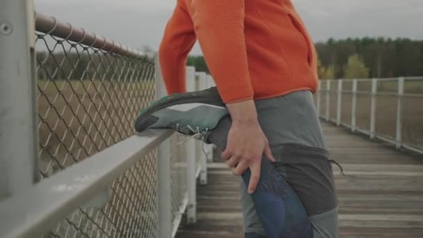 Turuncu Kalın Elbiseli Bir Adam Soğuk Sonbahar Havasında Ahşap Köprüde — Stok video