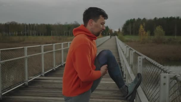 Mann Orangefarbener Und Warmer Kleidung Wärmt Sich Vor Dem Joggen — Stockvideo