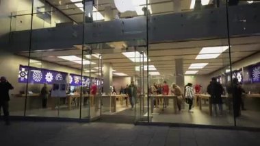 18 Kasım 2022. Münih. Almanya. Marienplatz manzaralı Apple Store 'un akşam ön cephesi. Apple mağazası cephesi iki kat, müşteriler taşınıyor, Apple logosu gece aydınlanıyor. Almanya 'da Alışveriş