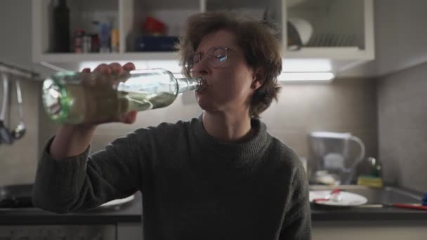 可怜的高加索女人喝着酒水 喝着瓶子里的白葡萄酒 在客厅的厨房里哭泣 度过了一个孤独的夜晚 压力和酗酒 — 图库视频影像
