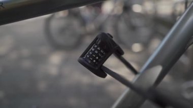 Hırsızlığa ve hırsızlığa karşı bisiklet sağlama almak. Bir motorun üzerindeki katlanmış metal kombinasyon kilidinin yakın çekimi. Dört haneli şifresi olan bir asma kilit. Bisikletler için araç hırsızlığı önleyici cihaz. 