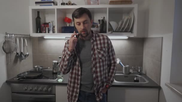 Een Droevige Man Die Thuis Keuken Met Een Mobieltje Praat — Stockvideo