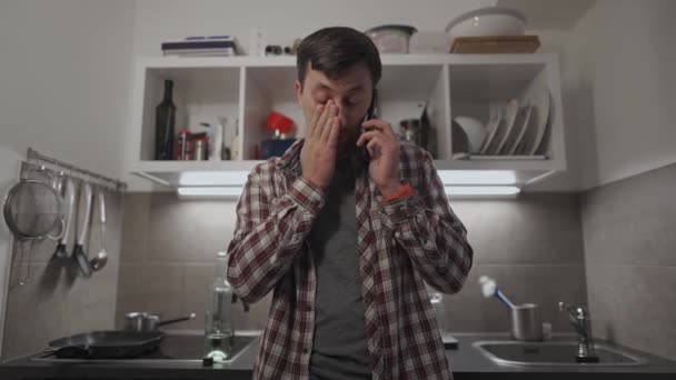 Een Droevige Man Die Thuis Keuken Met Een Mobieltje Praat — Stockvideo