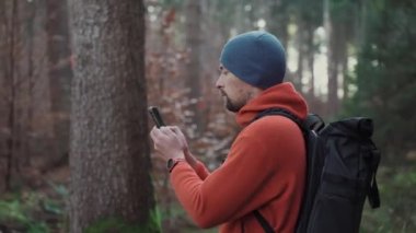 Yürüyüş yaparken açık hava haritaları. Yürüyüşçü, uygulama haritalama yoluyla ormanda yön bulmak için akıllı telefon kullanır. Akıllı telefondan güzergahlar çiziyor. Gezgin GPS kullanarak ormanda yolunu bulur. Keşfedin ve yürüyün. 