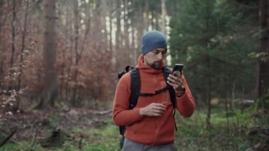 Doğa yürüyüşü için açık hava haritası. Yürüyüşçü bir uygulama ve dijital haritalar kullanarak ormanda gezinmek için akıllı telefon kullanır. Akıllı telefondan yürüyüş için rota. Gezgin ormanda GPS ile rehberlik ediyor. Seyahat et ve keşfet. 