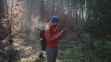 Doğa yürüyüşü için açık hava haritası. Yürüyüşçü bir uygulama ve dijital haritalar kullanarak ormanda gezinmek için akıllı telefon kullanır. Akıllı telefondan yürüyüş için rota. Gezgin ormanda GPS ile rehberlik ediyor. Seyahat et ve keşfet. 