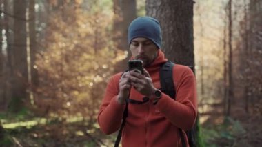 Yürüyüş yaparken açık hava haritaları. Yürüyüşçü, uygulama haritalama yoluyla ormanda yön bulmak için akıllı telefon kullanır. Akıllı telefondan güzergahlar çiziyor. Gezgin GPS kullanarak ormanda yolunu bulur. Keşfedin ve yürüyün. 