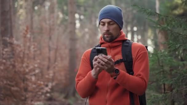 ハイキング中の屋外マッピング 人間のハイカーは スマートフォンを使ってアプリケーションやデジタルマップを使って森の中を移動します スマートフォンでのハイキングのためのルート Gpsで森の中の旅行ガイド 旅行と探索 — ストック動画