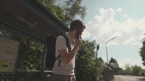 灰心丧气的男人等公共汽车停下来 然后用他的手机打电话 在德国 乘客们很生气 在车站等公共交通工具等了很长时间 交通延误和迟到 — 图库视频影像