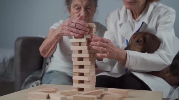 Pielęgniarka Pomaga Seniorom Rozwiązać Zagadkę Stara Kobieta Zaburzeniami Poznawczymi Klinice — Wideo stockowe