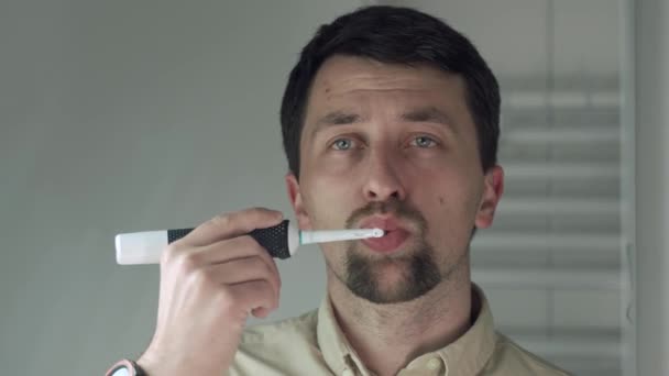 Homem Camisa Limpeza Dentes Por Escova Dentes Elétrica Banheiro Manhã — Vídeo de Stock