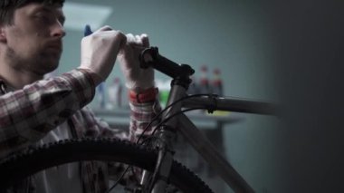 Benzin istasyonunda bisiklete bakım. Tamirci iş başında. Servis teknisyeni bisiklet sapı kuruyor. Bisikletin gidonunu ayarlıyorum. Bisiklet atölyesinde tornavidayla vida çevirme. 