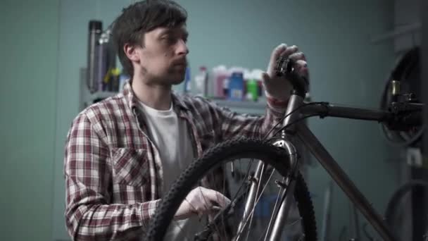 自行车修理工在自行车修整车间工作 自行车技师用特殊的工具扭动自行车杆和把手 修理工使用工具来安装手柄螺栓 单车服务 — 图库视频影像
