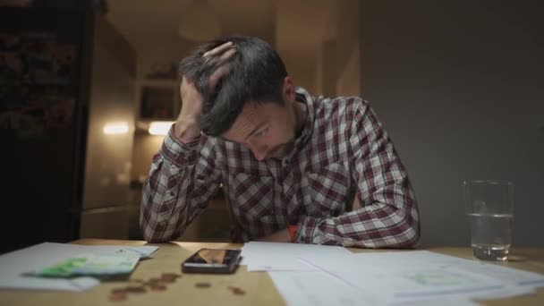 Разочарованный Человек Смотрит Счета Подсчитывает Деньги Калькуляторе Кухне Депрессивный Мужчина — стоковое видео