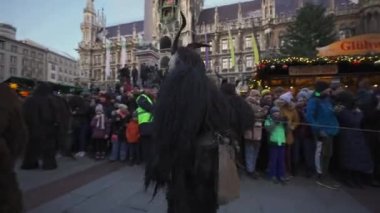 11 Aralık 2022. Münih. Almanya. Marienplatz 'da. Krampuslauf Uber den Munchner Christkindlmark. Krampus 'taki insanlar Münih' teki merkez meydanda maskeli Noel öncesi Krampus Festivali geçit töreninde. 