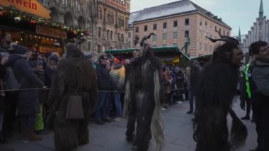 11 Aralık 2022. Münih. Almanya. Marienplatz 'da. Krampuslauf Uber den Munchner Christkindlmark. Krampus 'taki insanlar Münih' teki merkez meydanda maskeli Noel öncesi Krampus Festivali geçit töreninde. 