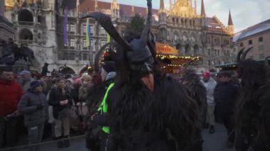 11 Aralık 2022. Münih. Almanya. Marienplatz 'da. Krampuslauf Uber den Munchner Christkindlmark. Krampus 'taki insanlar Münih' teki merkez meydanda maskeli Noel öncesi Krampus Festivali geçit töreninde. 