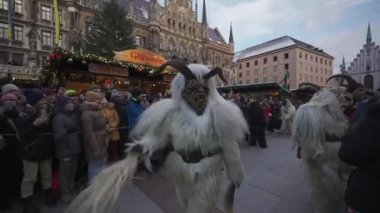 11 Aralık 2022. Münih. Almanya. Marienplatz 'da. Krampuslauf Uber den Munchner Christkindlmark. Krampus 'taki insanlar Münih' teki merkez meydanda maskeli Noel öncesi Krampus Festivali geçit töreninde. 