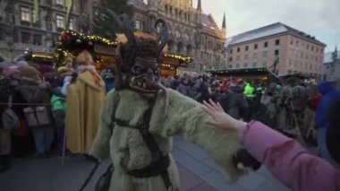 11 Aralık 2022. Münih. Almanya. Marienplatz 'da. Krampuslauf Uber den Munchner Christkindlmark. Krampus 'taki insanlar Münih' teki merkez meydanda maskeli Noel öncesi Krampus Festivali geçit töreninde. 