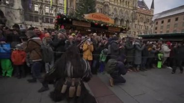 11 Aralık 2022. Münih. Almanya. Marienplatz 'da. Krampuslauf Uber den Munchner Christkindlmark. Krampus 'taki insanlar Münih' teki merkez meydanda maskeli Noel öncesi Krampus Festivali geçit töreninde. 
