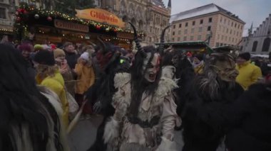 11 Aralık 2022. Münih. Almanya. Marienplatz 'da. Krampuslauf Uber den Munchner Christkindlmark. Krampus 'taki insanlar Münih' teki merkez meydanda maskeli Noel öncesi Krampus Festivali geçit töreninde. 