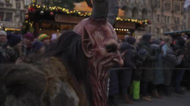 11 Aralık 2022. Münih. Almanya. Marienplatz 'da. Krampuslauf Uber den Munchner Christkindlmark. Krampus 'taki insanlar Münih' teki merkez meydanda maskeli Noel öncesi Krampus Festivali geçit töreninde. 