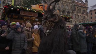 11 Aralık 2022. Münih. Almanya. Marienplatz 'da. Krampuslauf Uber den Munchner Christkindlmark. Krampus 'taki insanlar Münih' teki merkez meydanda maskeli Noel öncesi Krampus Festivali geçit töreninde. 