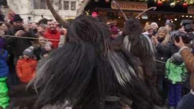 11 Aralık 2022. Münih. Almanya. Marienplatz 'da. Krampuslauf Uber den Munchner Christkindlmark. Krampus 'taki insanlar Münih' teki merkez meydanda maskeli Noel öncesi Krampus Festivali geçit töreninde. 