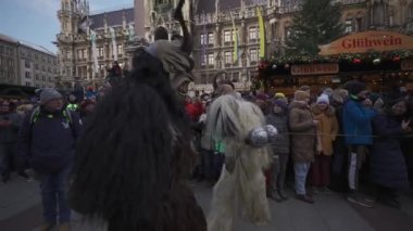 11 Aralık 2022. Münih. Almanya. Marienplatz 'da. Krampuslauf Uber den Munchner Christkindlmark. Krampus 'taki insanlar Münih' teki merkez meydanda maskeli Noel öncesi Krampus Festivali geçit töreninde. 