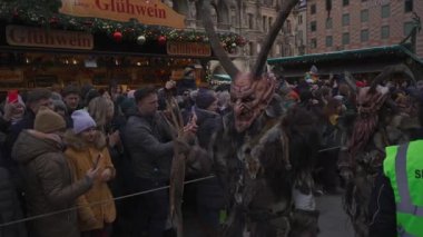 11 Aralık 2022. Münih. Almanya. Marienplatz 'da. Krampuslauf Uber den Munchner Christkindlmark. Krampus 'taki insanlar Münih' teki merkez meydanda maskeli Noel öncesi Krampus Festivali geçit töreninde. 