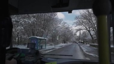 Münih, Almanya 'da karlı bir caddede bir otobüsün şoför tarafından çekilmiş görüntüsü. Kamu otobüsü vasıtasıyla kış mevsiminde ön cam manzarası. Kış, Avrupa ve toplu taşımacılık. 