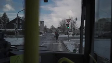 Almanya 'nın Münih şehrinde kış için otobüsün içinden ön cama bakın. Kar yağışlı havada belediye otobüsü ön pencereden izleniyor. Almanya 'da kar ve toplu taşıma. 