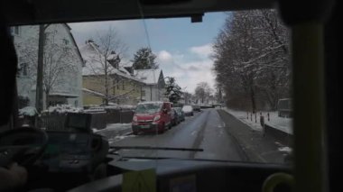 Münih, Almanya 'da karlı bir caddede bir otobüsün şoför tarafından çekilmiş görüntüsü. Kamu otobüsü vasıtasıyla kış mevsiminde ön cam manzarası. Kış, Avrupa ve toplu taşımacılık. 