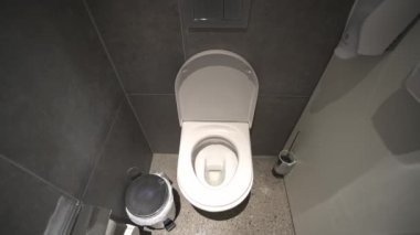 Çağdaş umumi tuvalet tuvaleti, temiz kase, duvara monte edilmiş tuvaletler, çöp kutusu ve dezenfektan. Temizlik odasındaki beyaz seramik tuvalette. Hijyen kavramı. 