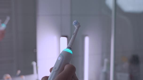 Erkek Elinin Beyazlı Ultrasonik Diş Fırçasını Açıp Kapayarak Banyonun Arka — Stok video