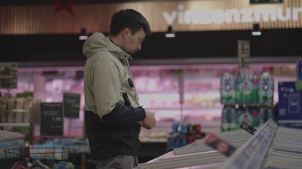 Man Shopper Auswahl Sorgfältig Gekühlte Produkte Tiefkühltruhen Supermarkt Winter Männliche — Stockvideo