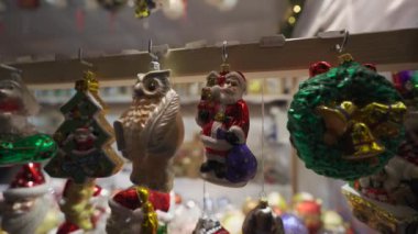 Almanya 'nın Münih kentindeki tatil köyü pazarındaki tezgahın ayrıntılı görüntüsü. Festival fuarında Noel süslemeleri. Kutlamak için dekoratif kış oyuncakları satıyorum. Sokak festivalinde satılacak ağaç heykelcikleri. 