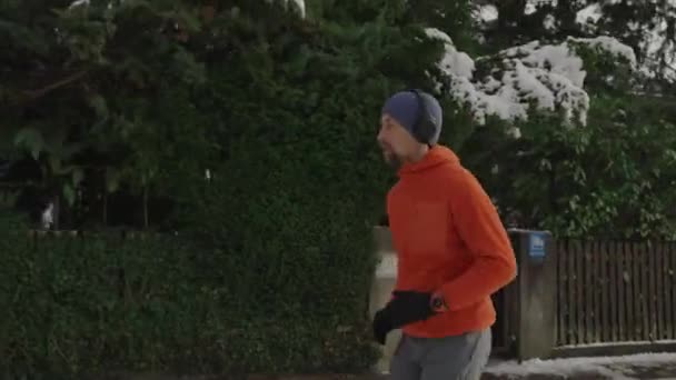 Man Jogging Snowy Path Park City Listening Music Earphones Winter — Vídeo de Stock