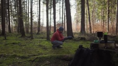 Camping, tourism and travel concept. Man setting up tent outdoors. Hiker assembles campsite tent in the autumnal forest. Traveler installing tent in autumn woods. Outdoor weekend Activity. 