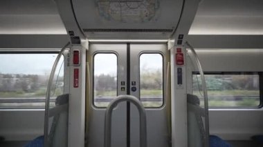 Inside sight of doors of commuter railway train during daytime with no people in Bavaria, Germany. Interior of railroad car looking automatic swinging door while moving. Rail transport in Deutschland