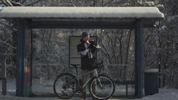 Frozen Male Cyclist Waiting Bus Halt Stop Bicycle Winter Snowy — Stock video
