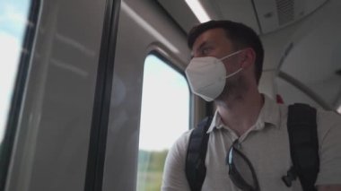 Almanya 'da 9 Euro' luk tren bileti kalabalık. Maskeli erkek yolcu trenin kapısında duruyor ve pencereden bakıyor, vagonda koltuk yok. Erkek sağlığına dikkat et. Hava arındırma için sis filtresiName. 