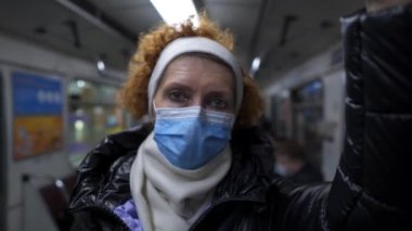 Underground travel with face mask. Health, safety and pandemic concept. Social distancing. Elderly passenger wearing protection from coronavirus covid 19 in subway in Kiev. Pandemic travel.