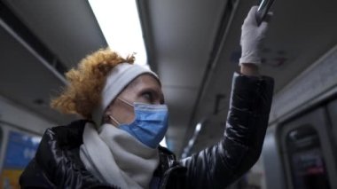 Mature passenger on subway wearing protective mask and latex gloves to protect against infection and virus during coronavirus, covid 19. Elderly female in public transport social distance, new norm.