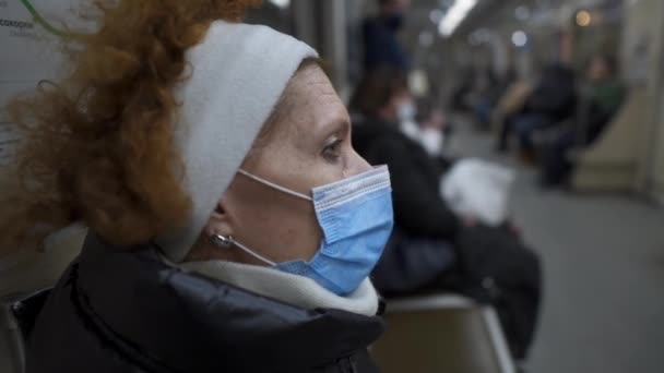 顔マスクで地下旅行 パンデミックの概念 社会的距離 コロナウイルスからの保護を身に着けている高齢者はキエフの地下鉄で19をCovid 流行旅行 — ストック動画
