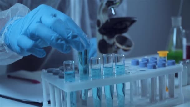 Βιοχημεία Εργαστηριακή Έρευνα Χημικός Προστατευτική Στολή Αναλύοντας Μπλε Δείγμα Στο — Αρχείο Βίντεο