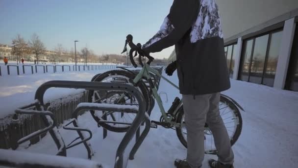 Cyclist Attaches Bicycle Lock Street Parking Germany Winter Sunny Snowy — Stok video
