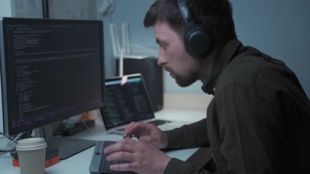 Young Male Software Developer Headsets Working Typing Keyboard Looking Focused — Stockvideo