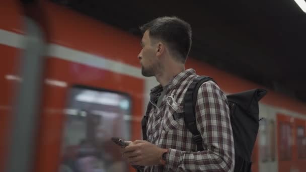 Man Smartphone Front Passing Train Munich Germany Passenger Backpack Uses — Stockvideo